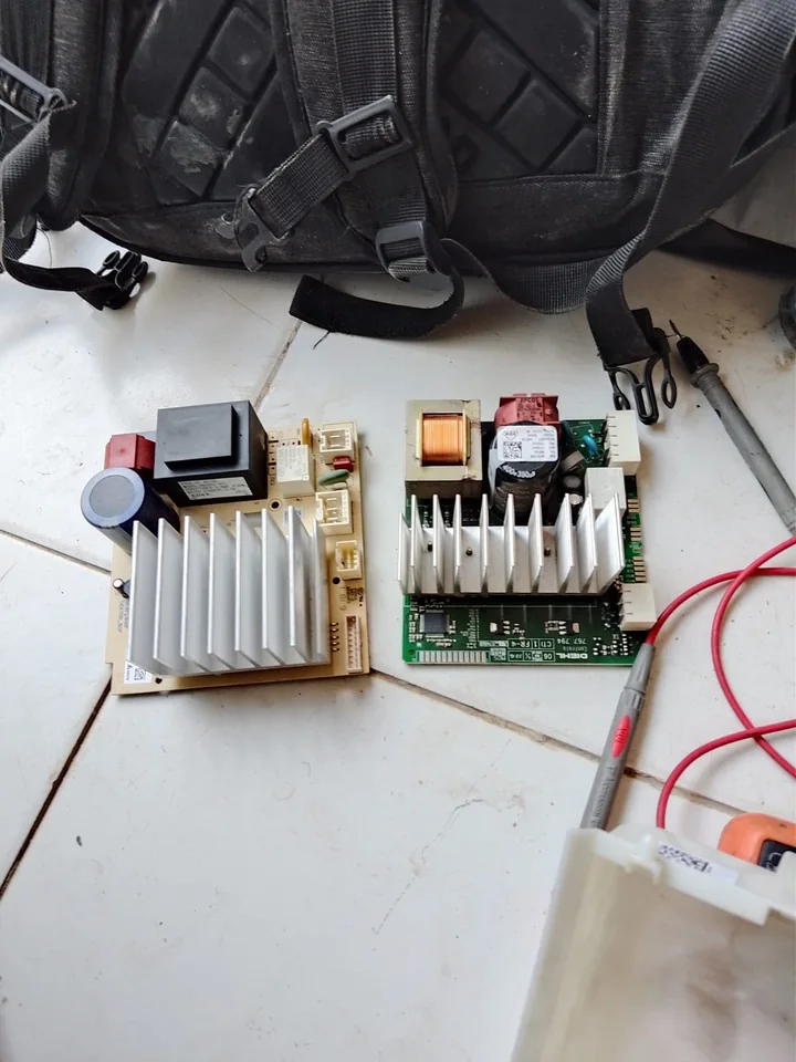 Two appliance control boards on the bench during repair