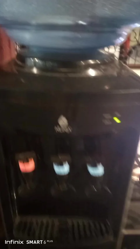 Black three-tap water dispenser with cold and hot lights on