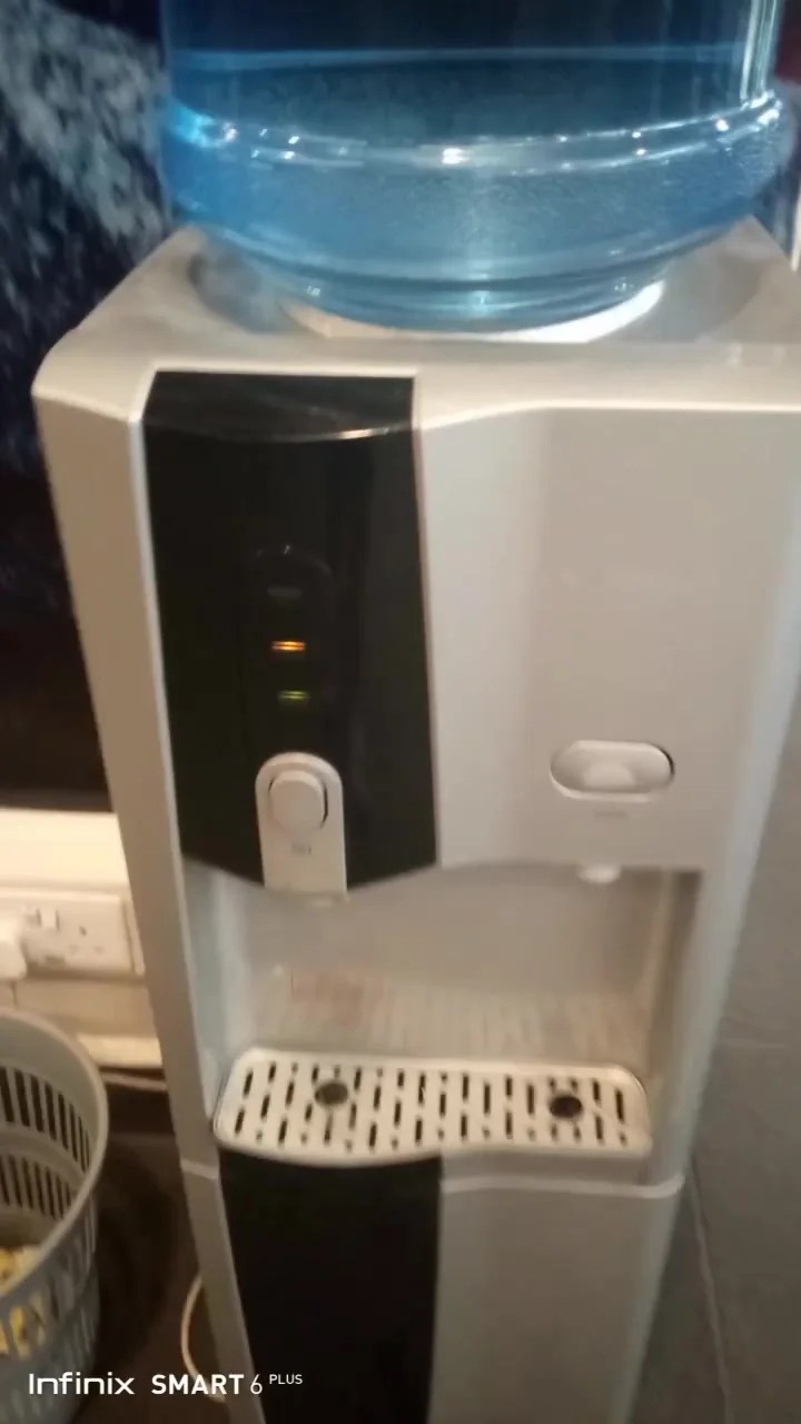 White top-load water dispenser on a repair visit