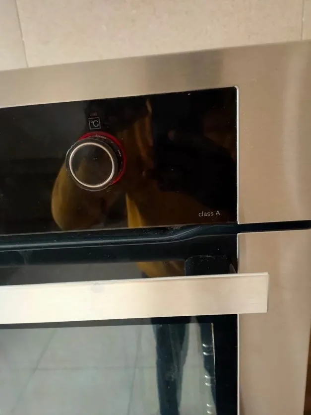 Built-in oven with the door open during a repair visit