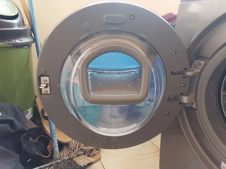 Front-load washing machine door open showing the glass and seal